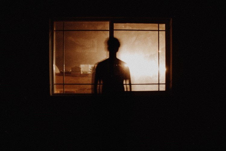 a silhouette of a man in front of a window